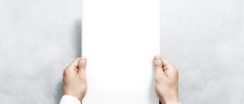 Hand holding white journal with blank cover mockup. Arm in shirt hold clear magazine template mock up. A4 book softcover surface design. Paperback print display show. Closed notebook cover showing.